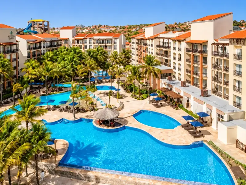 Resort com piscinas entre coqueiros, vista do alto