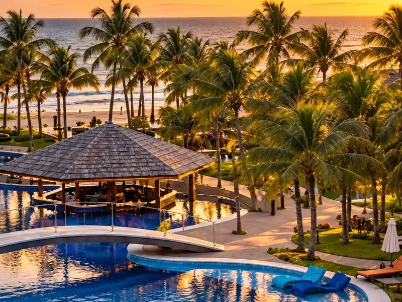 Piscina com bar e coqueiros à beira-mar, ao entardecer